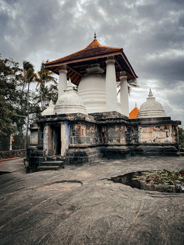 Historic Gadaladeniya Temple in Sri Lanka with traditional architecture under a moody sky.